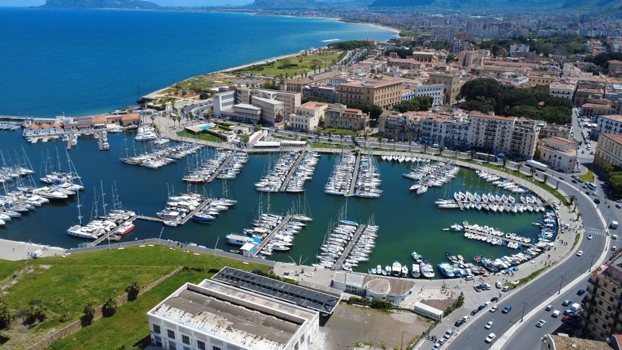 Explore the vibrant marina and urban landscape of Palermo from above, showcasing bustling harbor life.