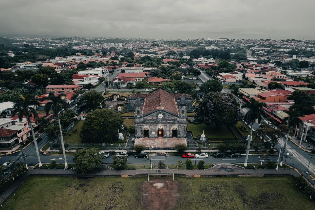 Scenic aerial view of a historic church surrounded by urban landscapes in Flores, Costa Rica.