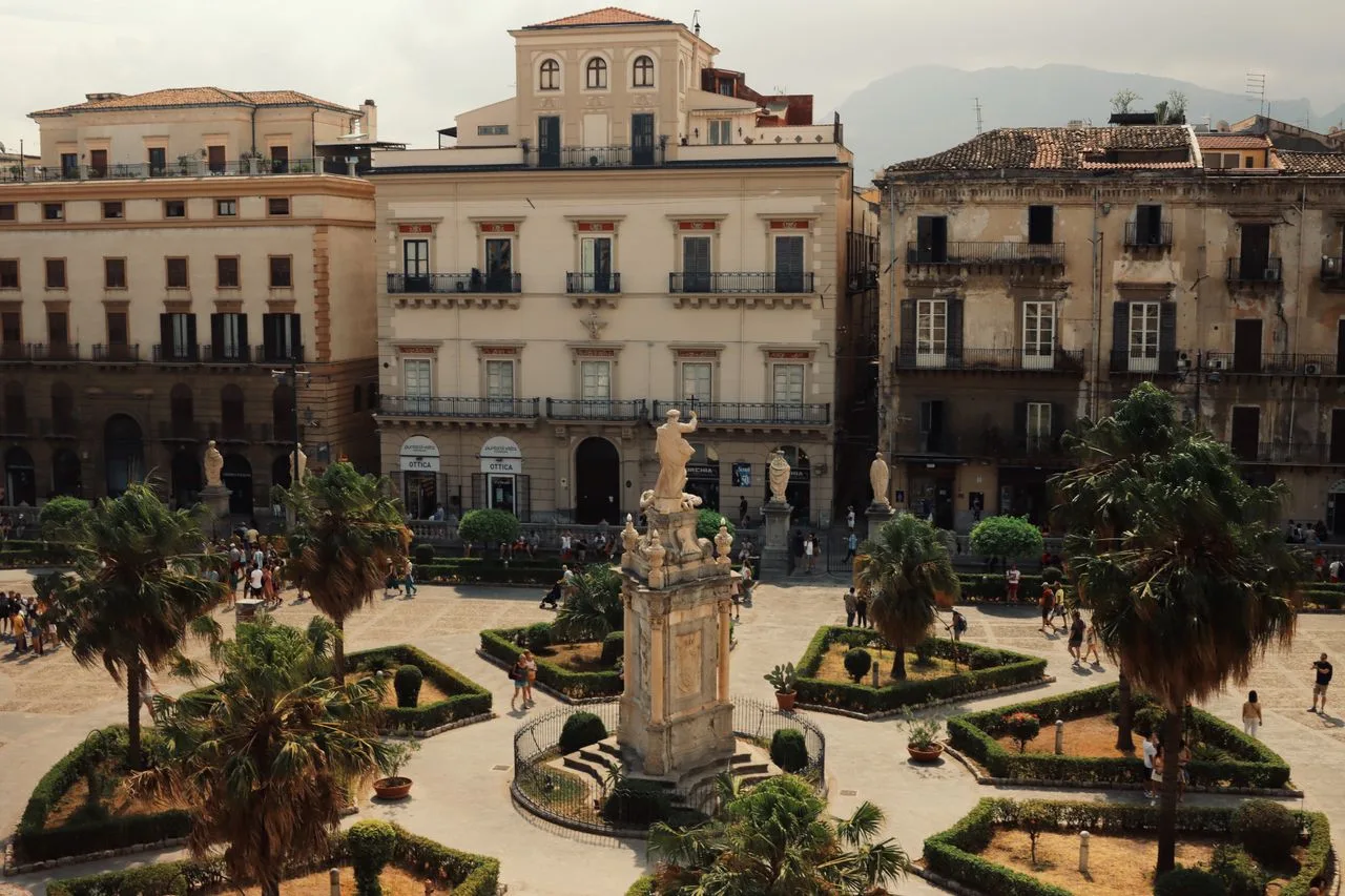 Aerial shot of a historic piazza in Palermo, Italy with landmarks and urban architecture.