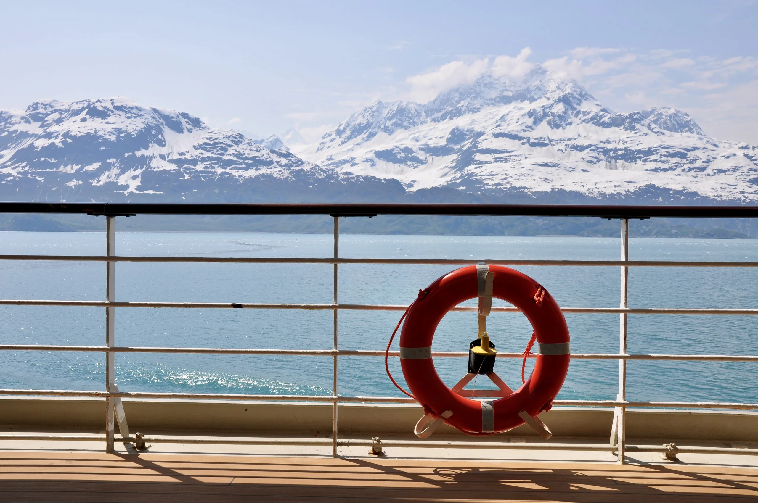 Scenic view of snowy mountains from a cruise ship in Alaska, highlighting nature's beauty.