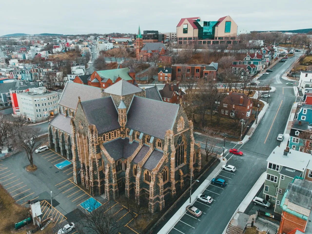 Aerial shot of a historic church surrounded by a scenic cityscape on an overcast fall day.