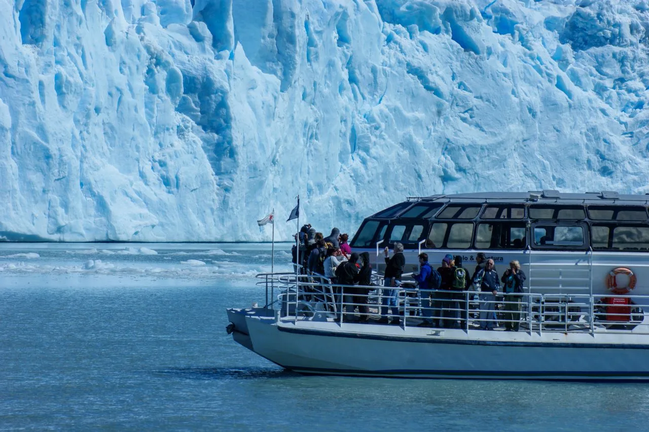 Tourists on a boat exploring icy glaciers in Patagonia's stunning landscape.