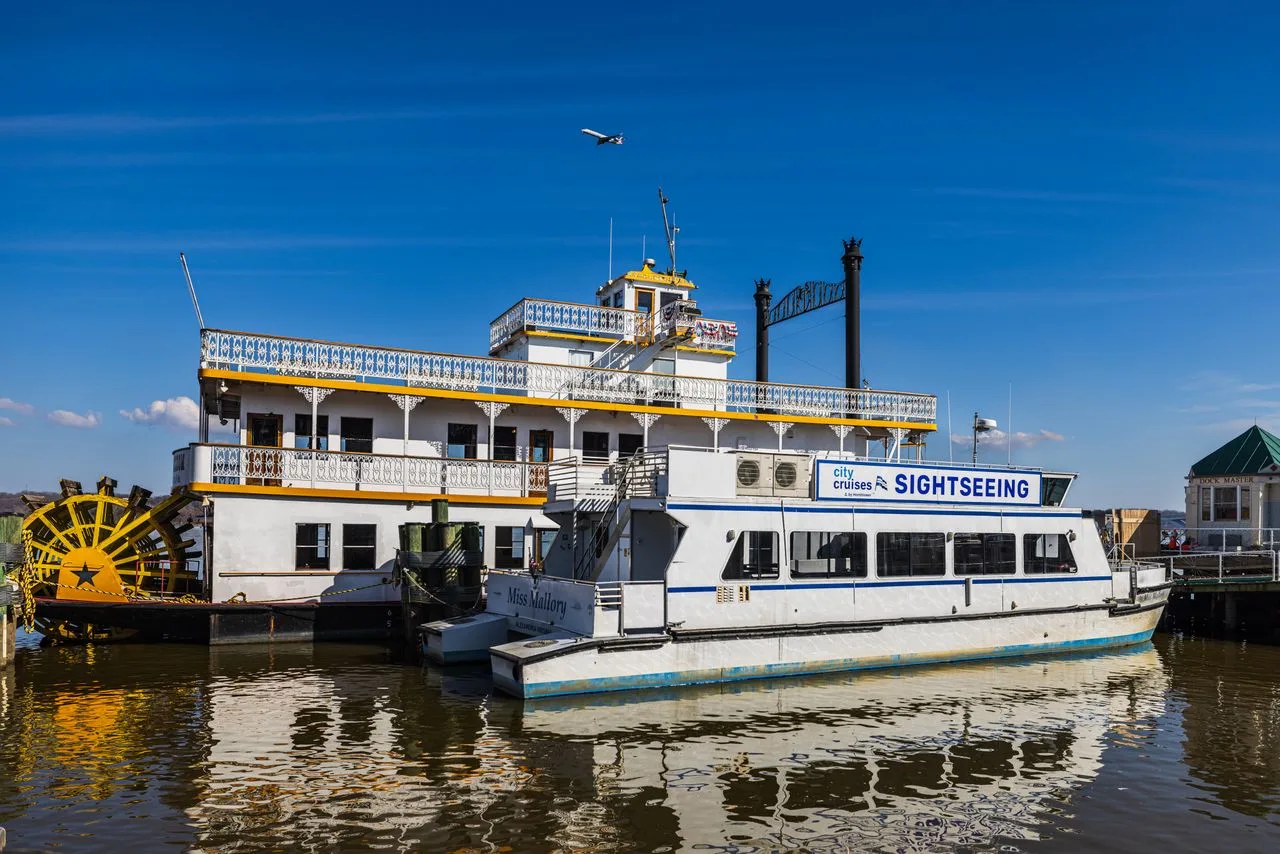 A paddle steamer and sightseeing cruise ship docked under a bright blue sky, perfect for travel enthusiasts.