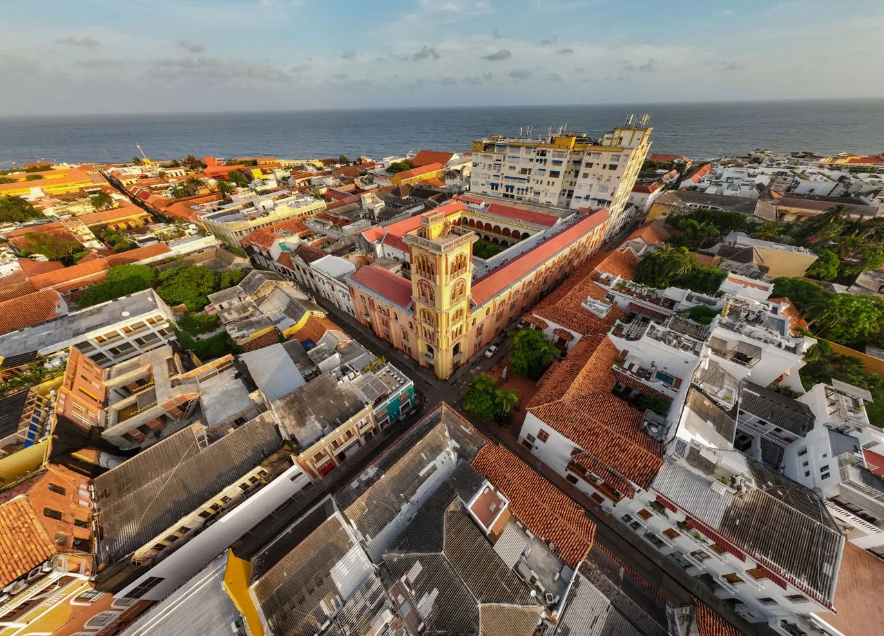 A stunning aerial shot of a coastal town with historic architecture and vibrant rooftops by the sea.