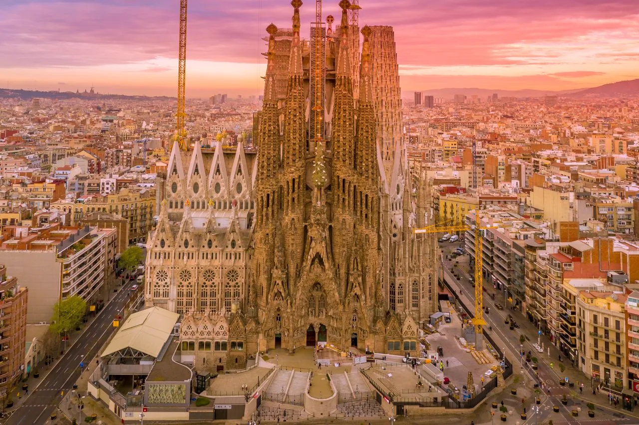 A breathtaking aerial capture of the Sagrada Familia in Barcelona during a vibrant sunset.