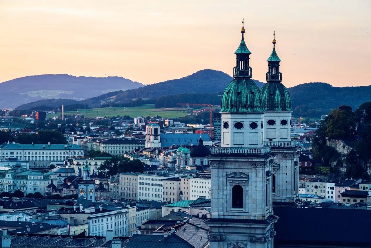 A scenic aerial view of Salzburg with prominent church towers at sunrise.