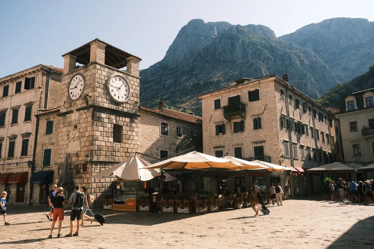 Explore the historic clock tower and stone houses in the heart of Kotor's old town, Montenegro.