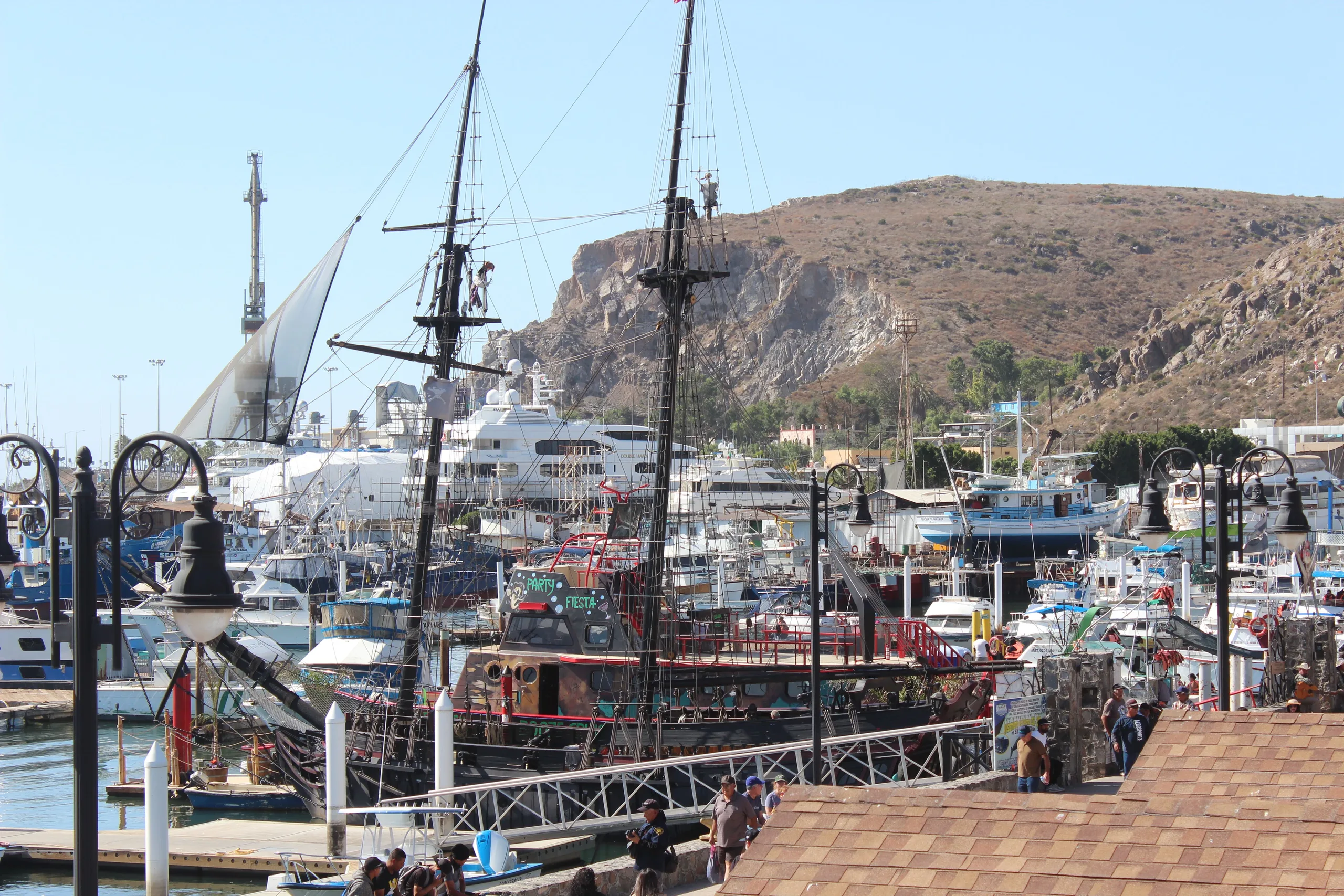 Vibrant port with boats and ships in Ensenada, B.C., Mexico, under a bright summer sky.