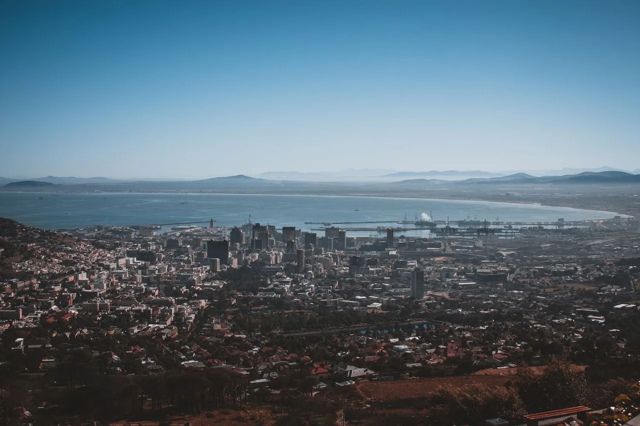 Stunning aerial view of Cape Town cityscape and Table Bay under a clear blue sky.