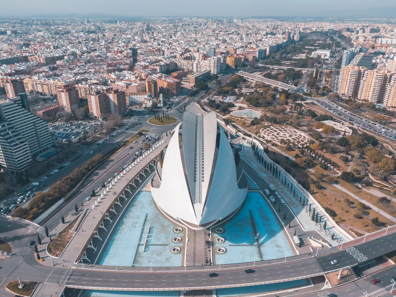 Stunning aerial shot of modern architectural landmark surrounded by urban cityscape.