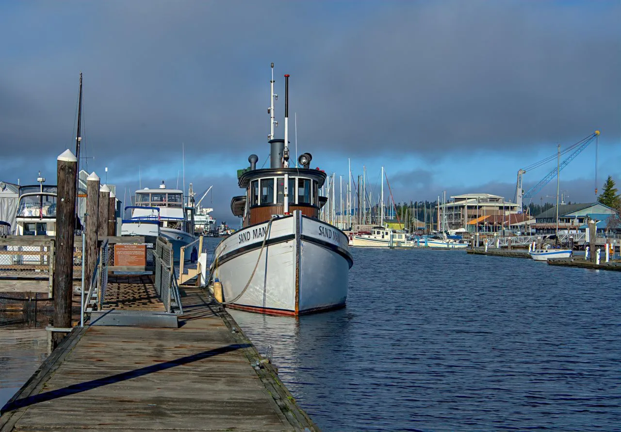 A serene view of a docked fishing boat in Olympia's harbor, capturing the peaceful morning atmosphere.