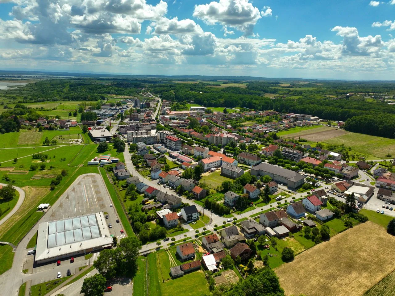 Vibrant aerial photograph showcasing the town of Garešnica, Croatia with lush greenery and clear skies.